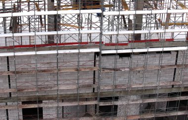 Konut binalarının inşaatı. İskele iskelesi. İnşaat işleri kışın yapılır. Dairelerin satın alınması.