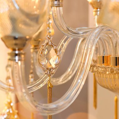 İçerideki avizenin şeffaf camında asılı duran bir damlanın kristal dekoru. Lüks tasarım kavramı. Kapatın. Yumuşak sıcak filtre, seçici odak.