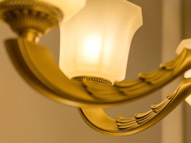 Klasik bir tavan avizesi görüntüsü. Altın renkli bir armatür üzerinde beyaz, buzlu bir plato var. İçerideki aydınlatma kavramı. Yumuşak sıcak filtre, seçici odak.