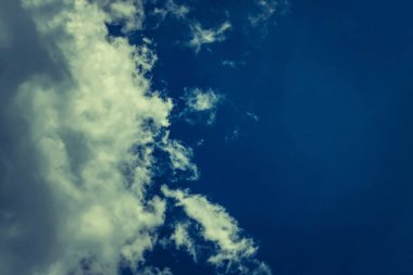 Alacakaranlık ışığında kabarık beyaz güneş bulutları koyu mavi gökyüzüne doğru süzülür. İlahi görüş. Kavram ve arka plan rüyası, güvenlik, güvenlik, güvenilir, Cadılar Bayramı. Boşluğu kopyala