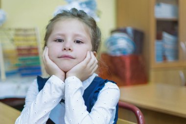 Önemsiz bir ilkokul öğrencisi bir masada oturur ve bir ders dinler. Bilgi günü. Eylül 'ün ilk günü. Okul yılının başlangıcı. Eğitim kavramı.