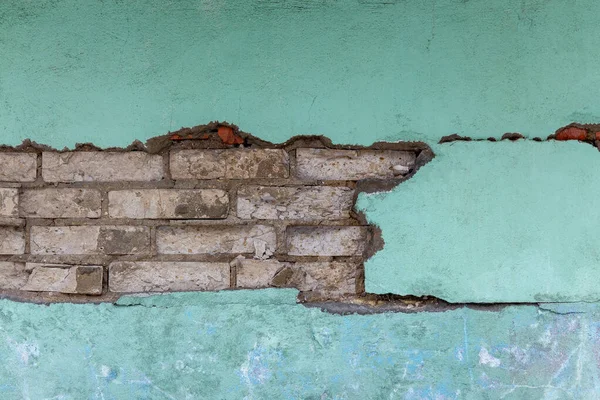 Beyaz çatallı, yıllanmış tuğla duvar. Grunge tarzı. Tasarımcı için yaratıcı fotoğraf. Yeşil arka plan. Uzayı kopyala Kapat..
