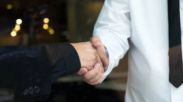 Dos hombres de negocios dándose la mano saludándose — Foto de Stock