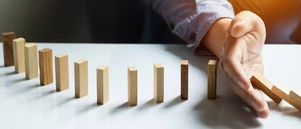 Business man hand stop dominoes — стоковое фото