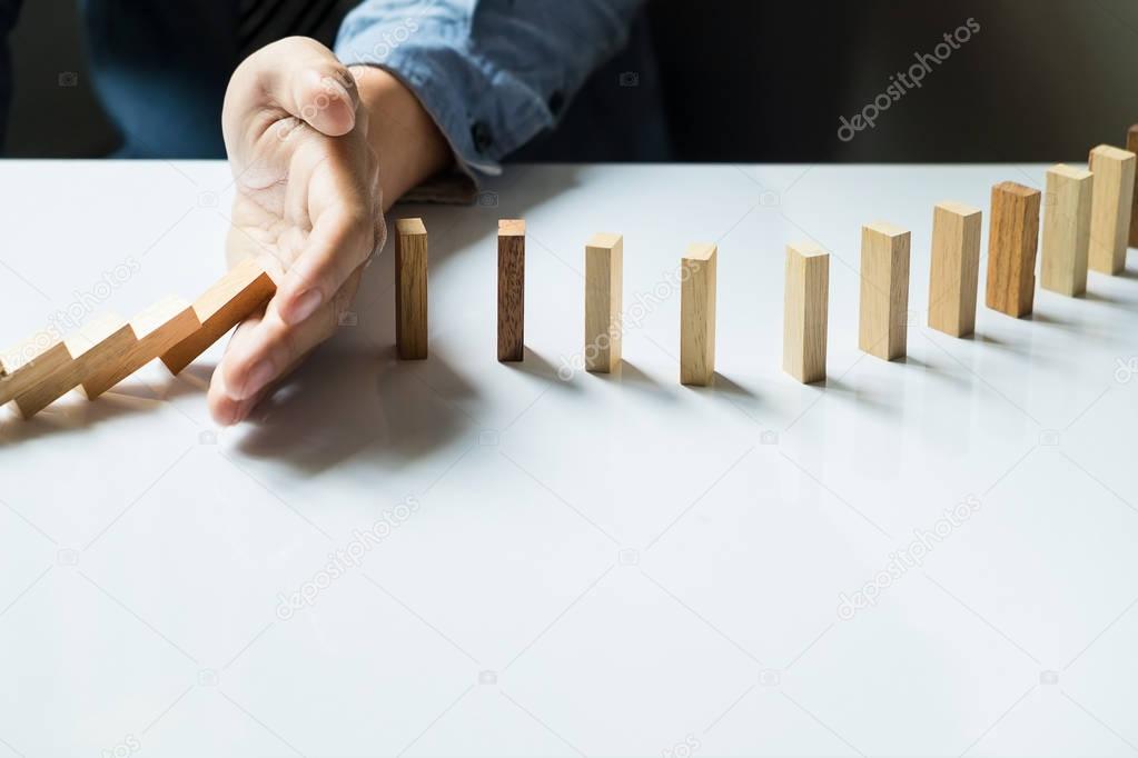 businessman hand stop dominoes