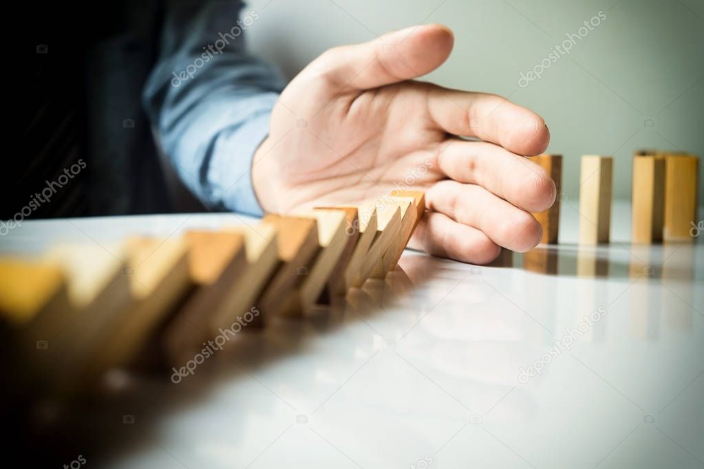 businessman hand stop dominoes continuous toppled or risk 