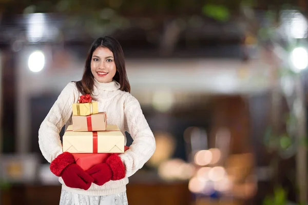 Asian christmas girl with gifts over light night winter backgrou — Stock Photo, Image