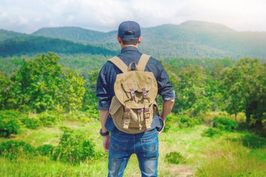 Sırt çantası ile kayalık mou açık rahatlatıcı ile genç adam Traveler