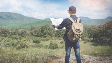 Harita sırt çantası ile kayalık açık rahatlatıcı ile genç adam Traveler