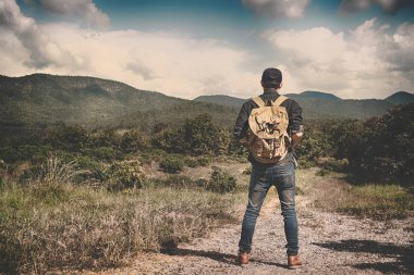 Sırt çantası ile kayalık mou açık rahatlatıcı ile genç adam Traveler