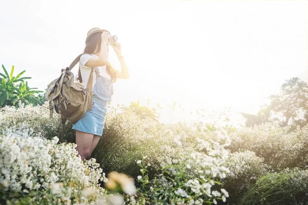 Asiático hipster lindo adolescente chica con cámara en blanco flor jardín , —  Fotos de Stock