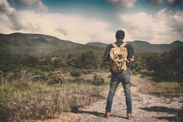 Sırt çantası ile kayalık mou açık rahatlatıcı ile genç adam Traveler