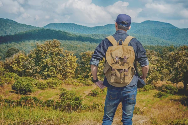 Joven viajero con mochila relajante al aire libre con mou rocoso — Foto de Stock