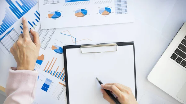 Portrait of business woman with laptop, finance graph and writes