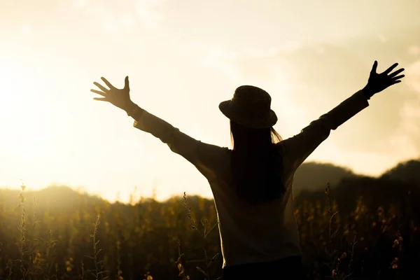 Glückliche Frau bleibt draußen im Blumengarten unter Sonnenlicht — Stockfoto