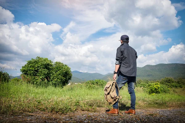 Jovem viajante com mochila relaxante ao ar livre com mou rochoso — Fotografia de Stock