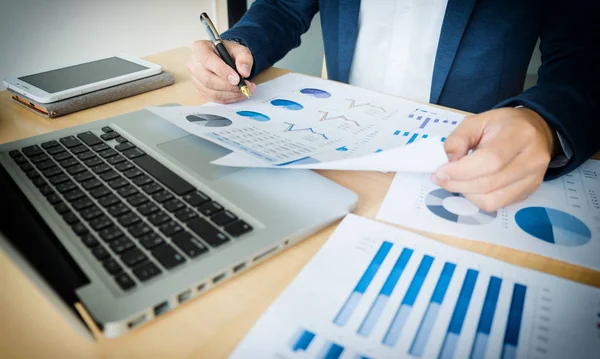 Geschäftsmann arbeitet im Büro mit Laptop, Tablet und Grafik — Stockfoto