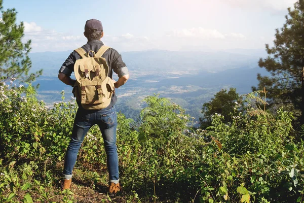 Joven viajero con mochila relajante al aire libre con mou rocoso — Foto de Stock