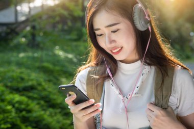 Genç Asyalı hipster giymek sm üzerinden müzik kulaklık