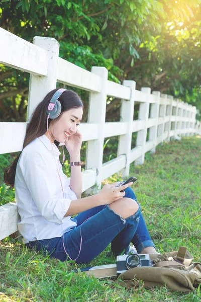 Genç Asyalı hipster giymek sm üzerinden müzik kulaklık