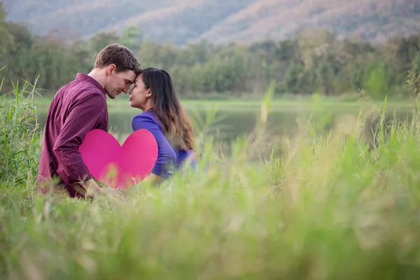 Una pareja amorosa. Hermosa pareja de amor joven sosteniendo corazones de papel — Foto de Stock