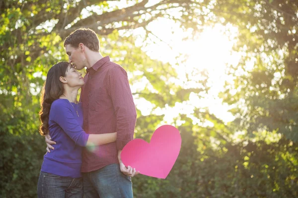 Una pareja amorosa. Hermosa pareja de amor joven sosteniendo corazones de papel — Foto de Stock