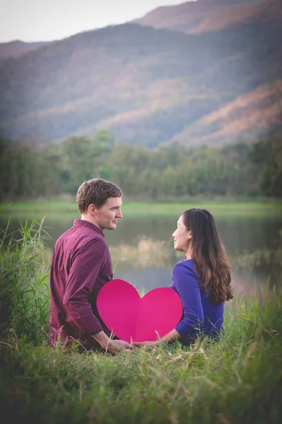 Una pareja amorosa. Hermosa pareja de amor joven sosteniendo corazones de papel — Foto de Stock