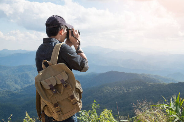 Young professional travrler man with camera shooting outdoor, fa