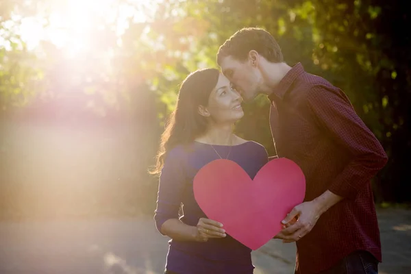 Älskande par. Vacker ung kärlek par håller Pappershjärtan — Stockfoto