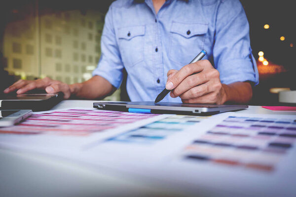 Creative businessman or designer writing on graphic tablet while