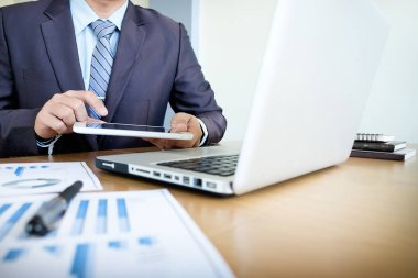 Çoklu görev. Yakışıklı genç adam touchpad sit süre ile çalışma