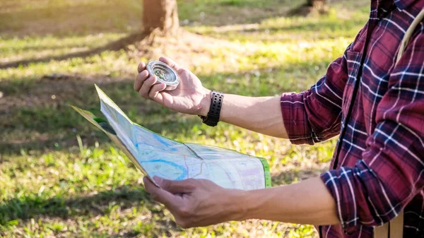 Förlorade turist i en vandring med kompass siktar riktningen i th — Stockfoto