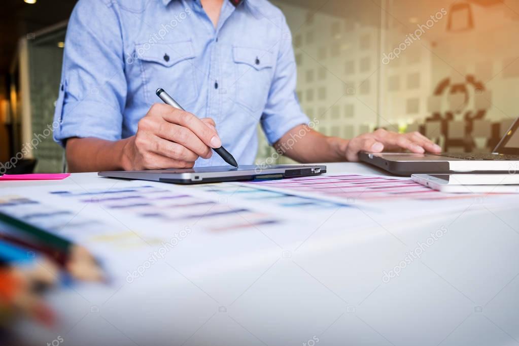 Creative businessman or designer writing on graphic tablet while