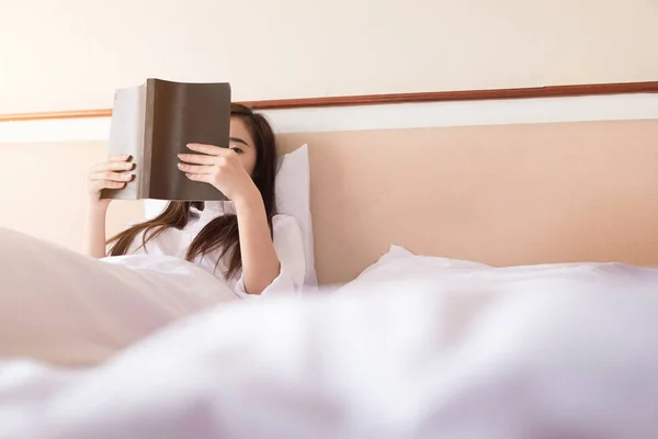 Wanita membaca buku dan minum kopi di tempat tidur pada pagi hari — Stok Foto