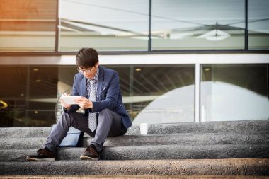 Tablet pc açık havada, altın sunligt kullanarak Asya Hintli işadamı