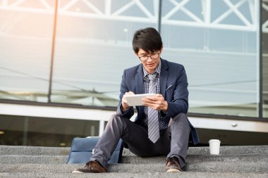 Açık havada tablet kullanan bir işadamı