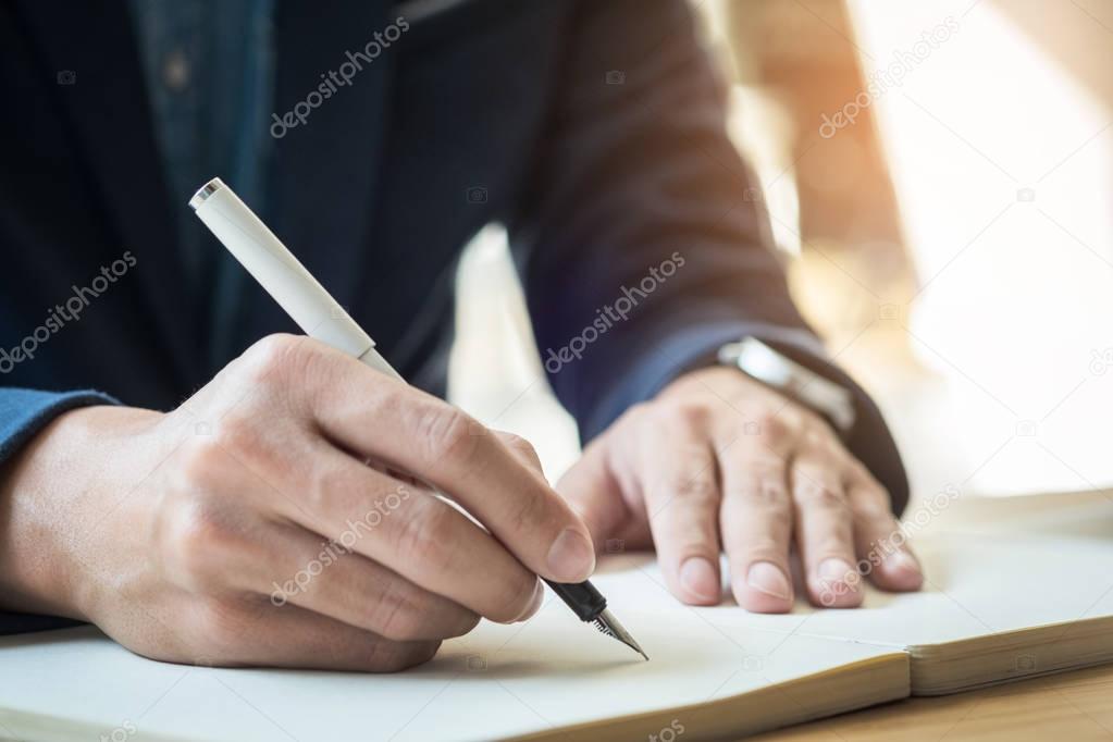 Businessman writing in notebook 