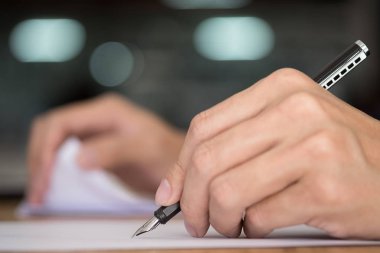 Bir belgede yazılı iş adamı. Kalemin ucunu odaklanmak