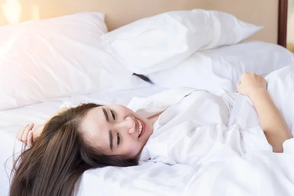 Portræt af en smuk kvinde afslappende i sengen - Stock-foto