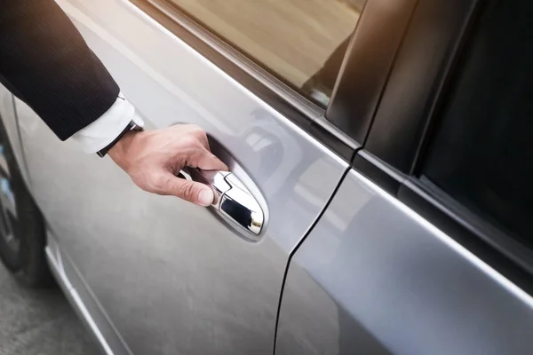 Chauffeur s hand on handle. Close-up of man in formal wear openi — Stock Photo, Image