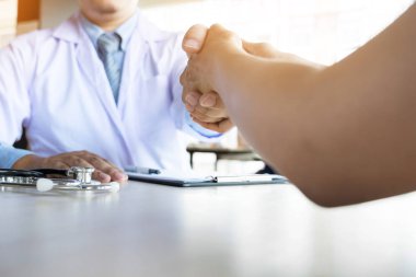 Doktor eller tıbbi ofiste glas giyen hastayla sallıyor