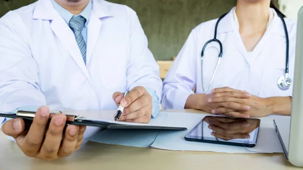 Dois médicos discutindo anotações de pacientes — Fotografia de Stock