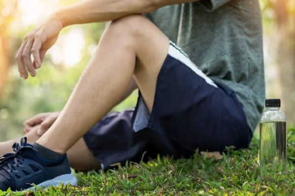 Atleta di sesso maschile sta riposando sull'erba — Foto Stock