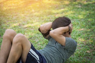 adam olun bir parkta egzersiz abs