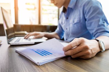 Genç yakışıklı iş adamı ofiste belgelerle çalışma