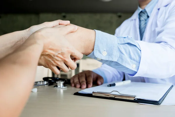 El doctor da la mano en el consultorio médico con el paciente, vistiendo vidrio — Foto de Stock