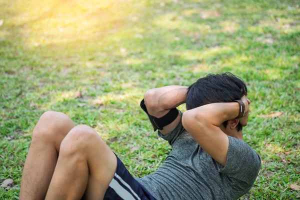 L'uomo fa esercizi addominali in un parco — Foto Stock