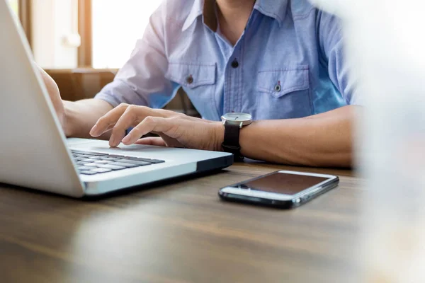 Attractive  man in casual business sitting at a table working on — Stock Photo, Image