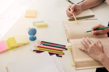 Genç kadın ve erkek bir test için eğitim / bir sınav. Öğretmen kitapları wi