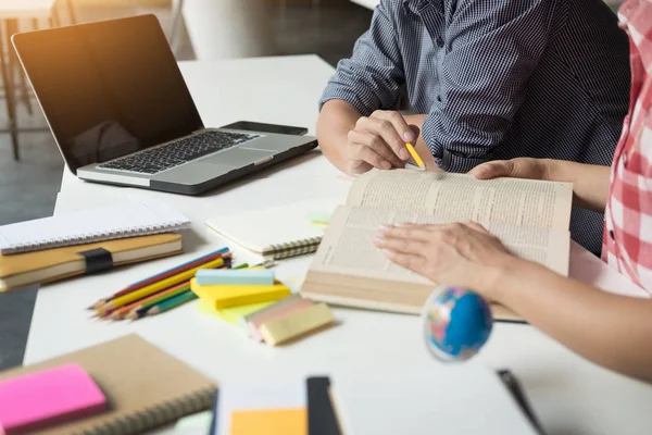 Young woman and man studying for a test/ an exam. Tutor books wi